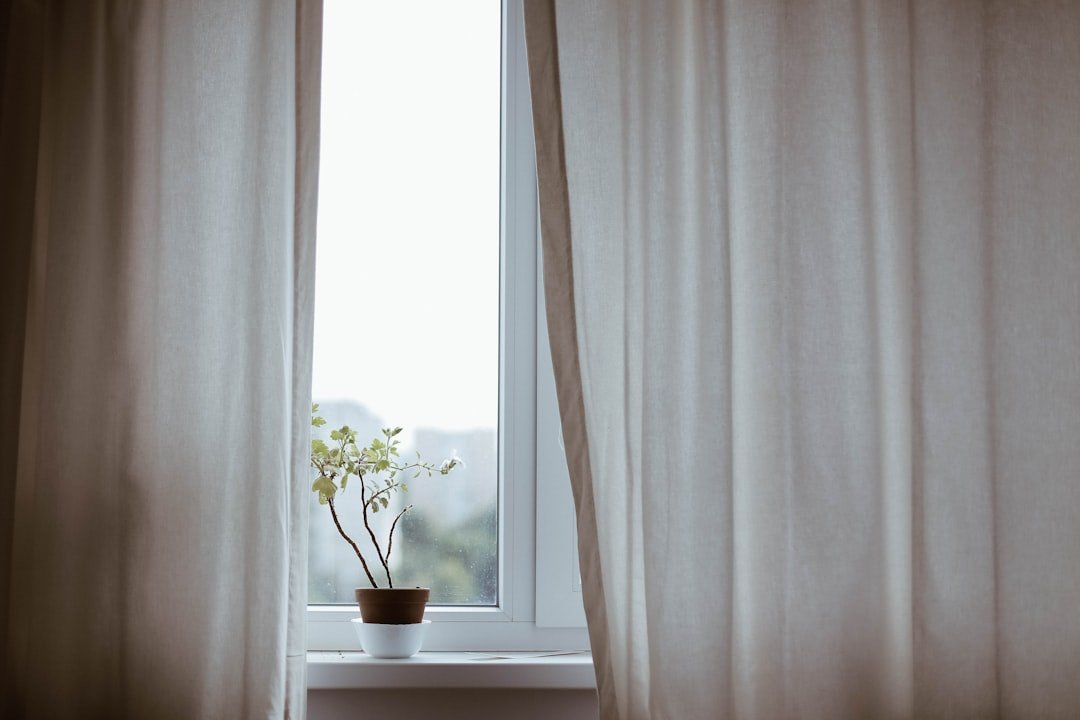 Curtains hung high on a window in a cozy room