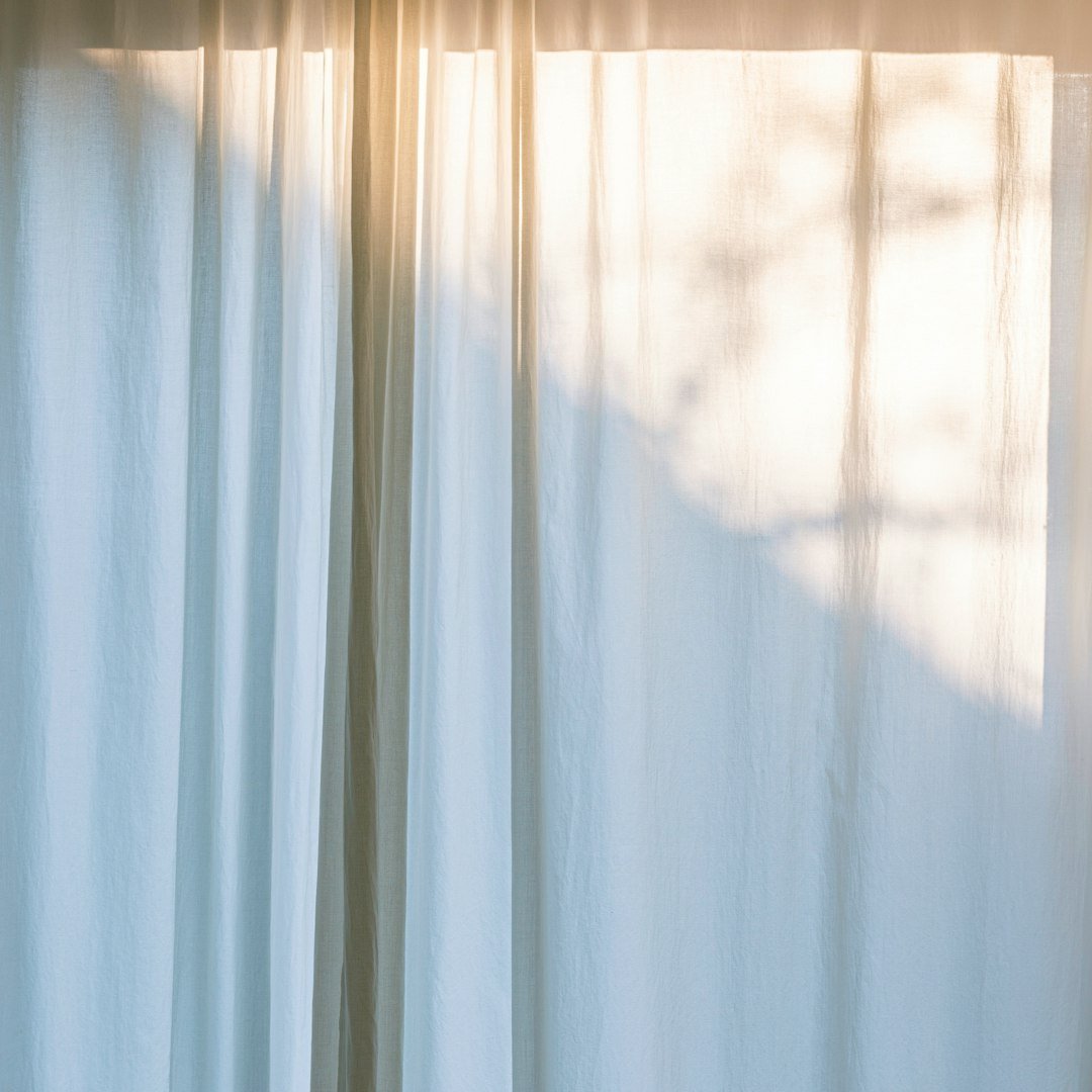 Layered curtains softening bedroom window light