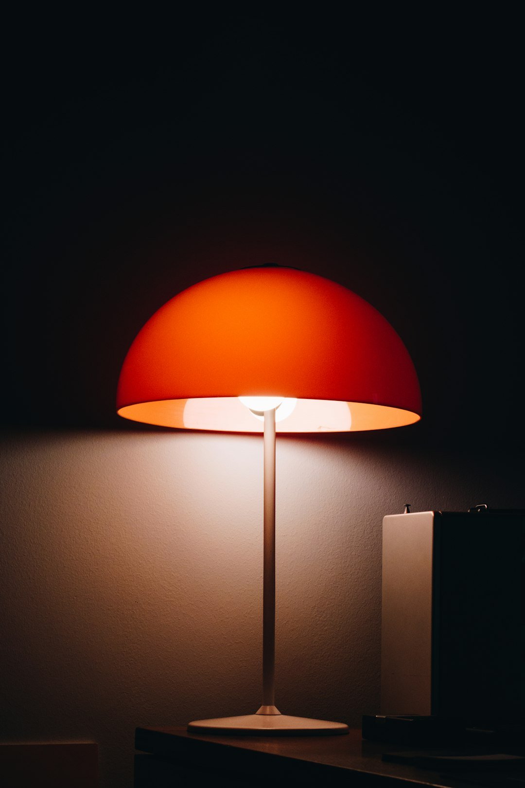 Warm lamp glow beside the bed in the evening