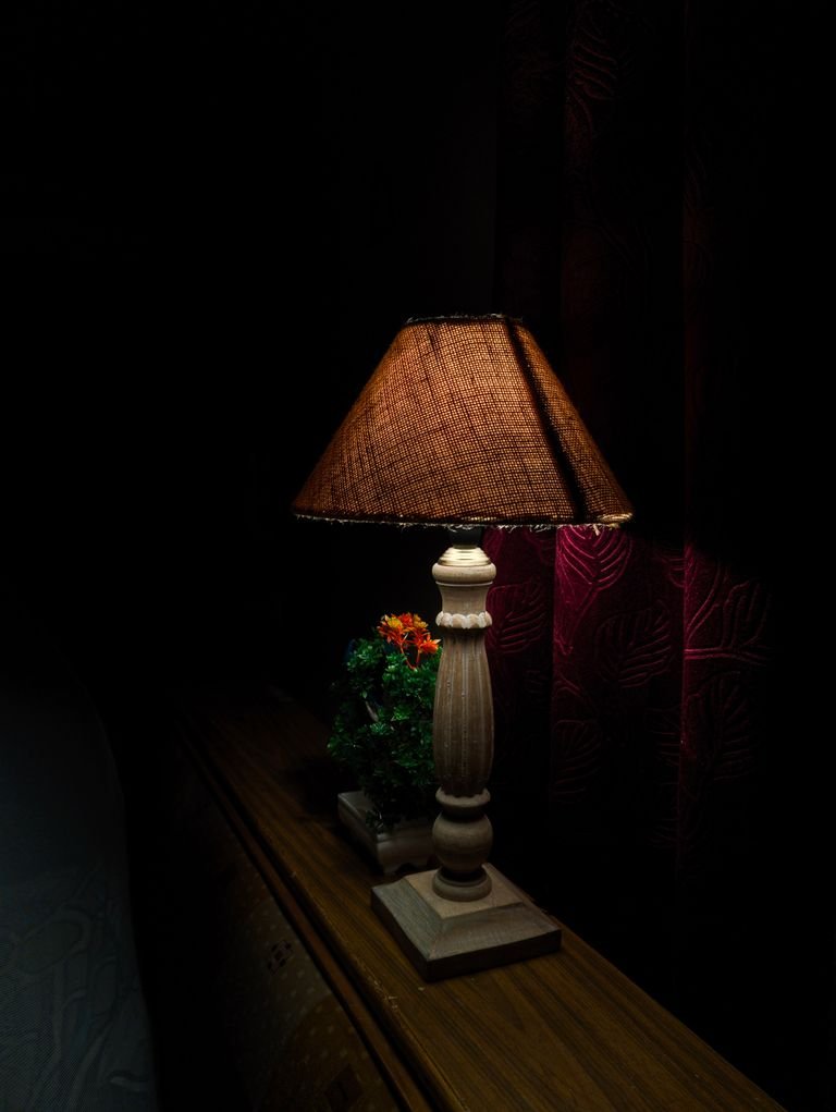 Cozy small bedroom with warm bedside lighting and a soft glow.