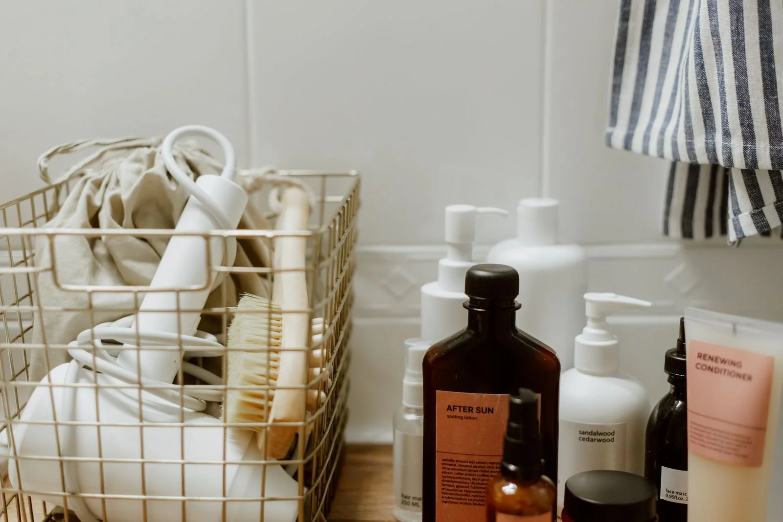 Wire basket of bathroom products and accessories on a wooden shelf — one caddy for a small bathroom morning routine