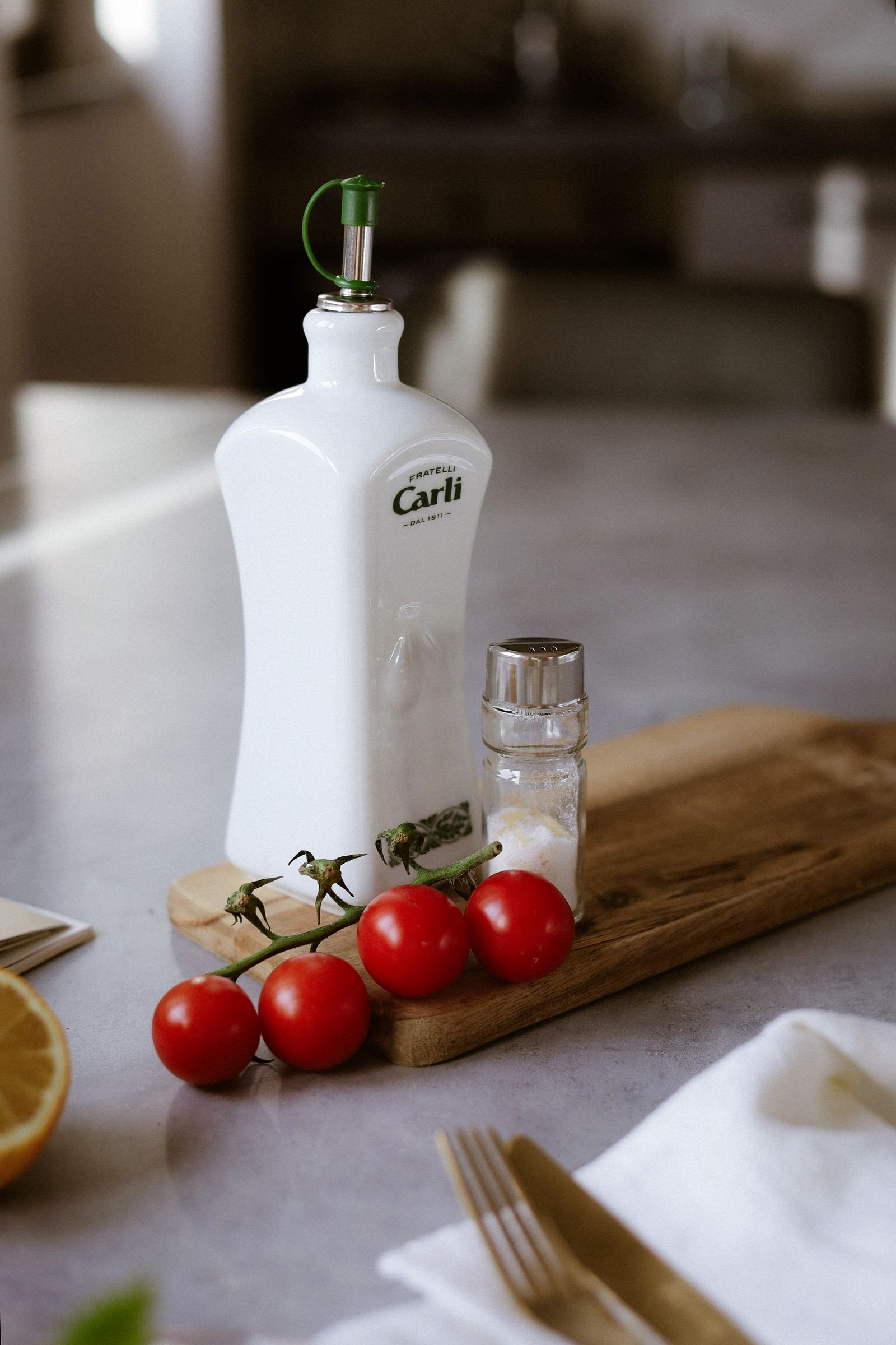 Olive oil bottle, tomatoes and salt on a wooden board within easy reach — small kitchen cooking ideas