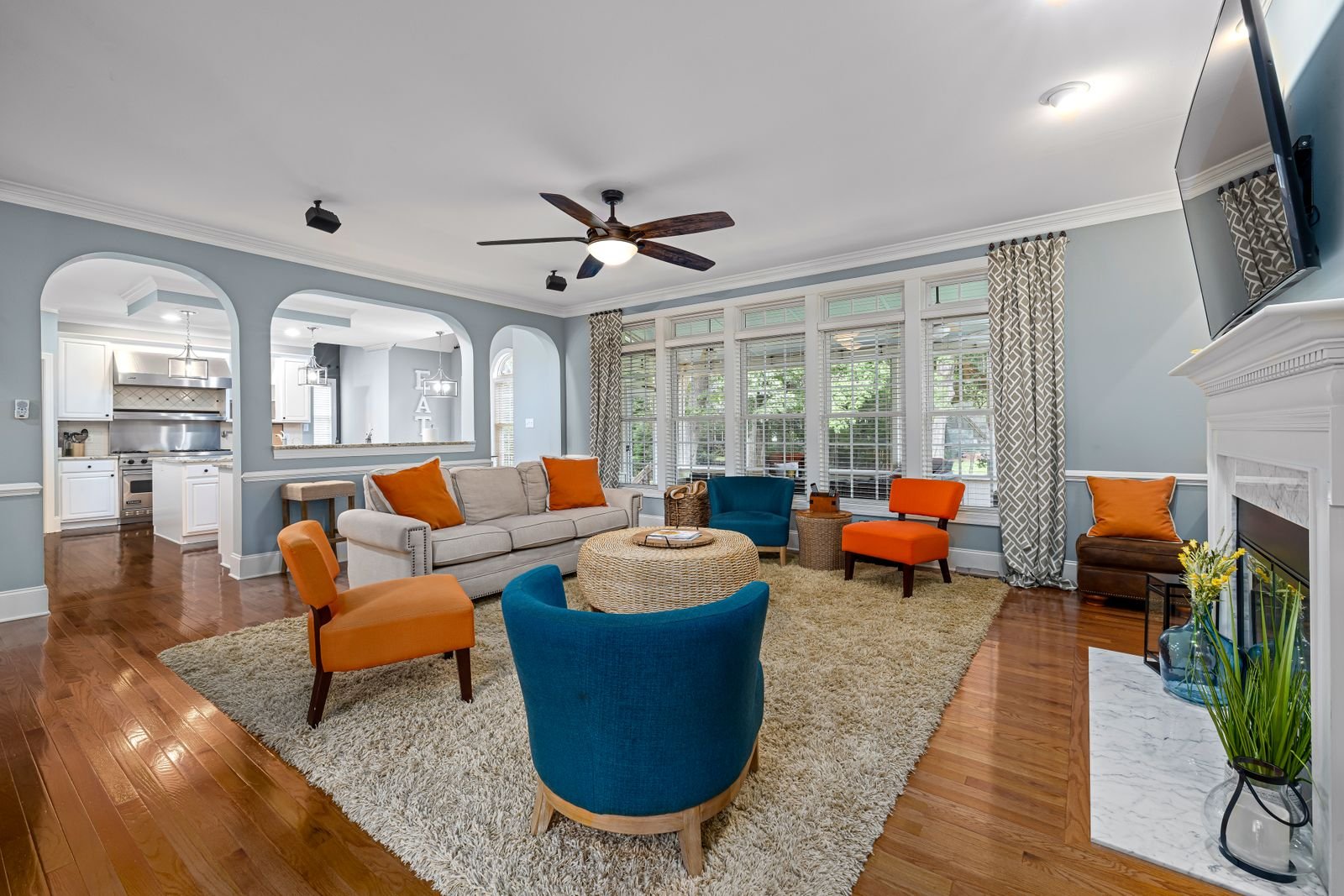 Sofa and armchairs arranged on a rug in a living room — one accent chair angled into the room