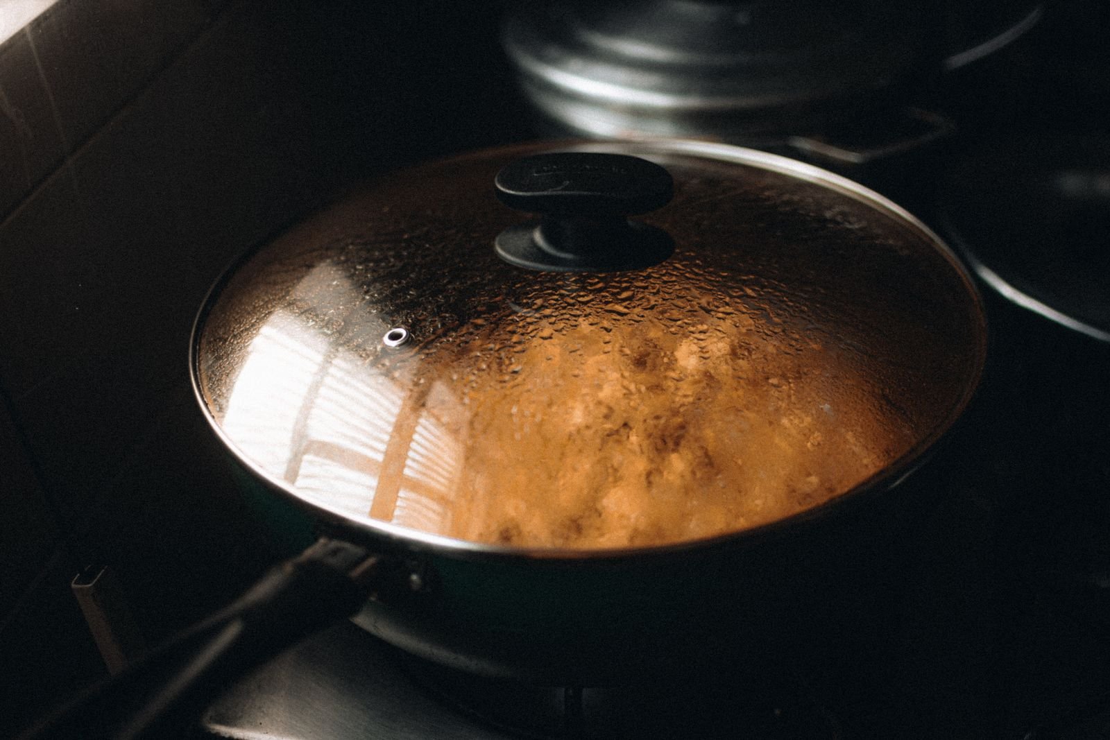 Steaming pan with its lid on — lids on to cut steam and splatter in small kitchen cooking