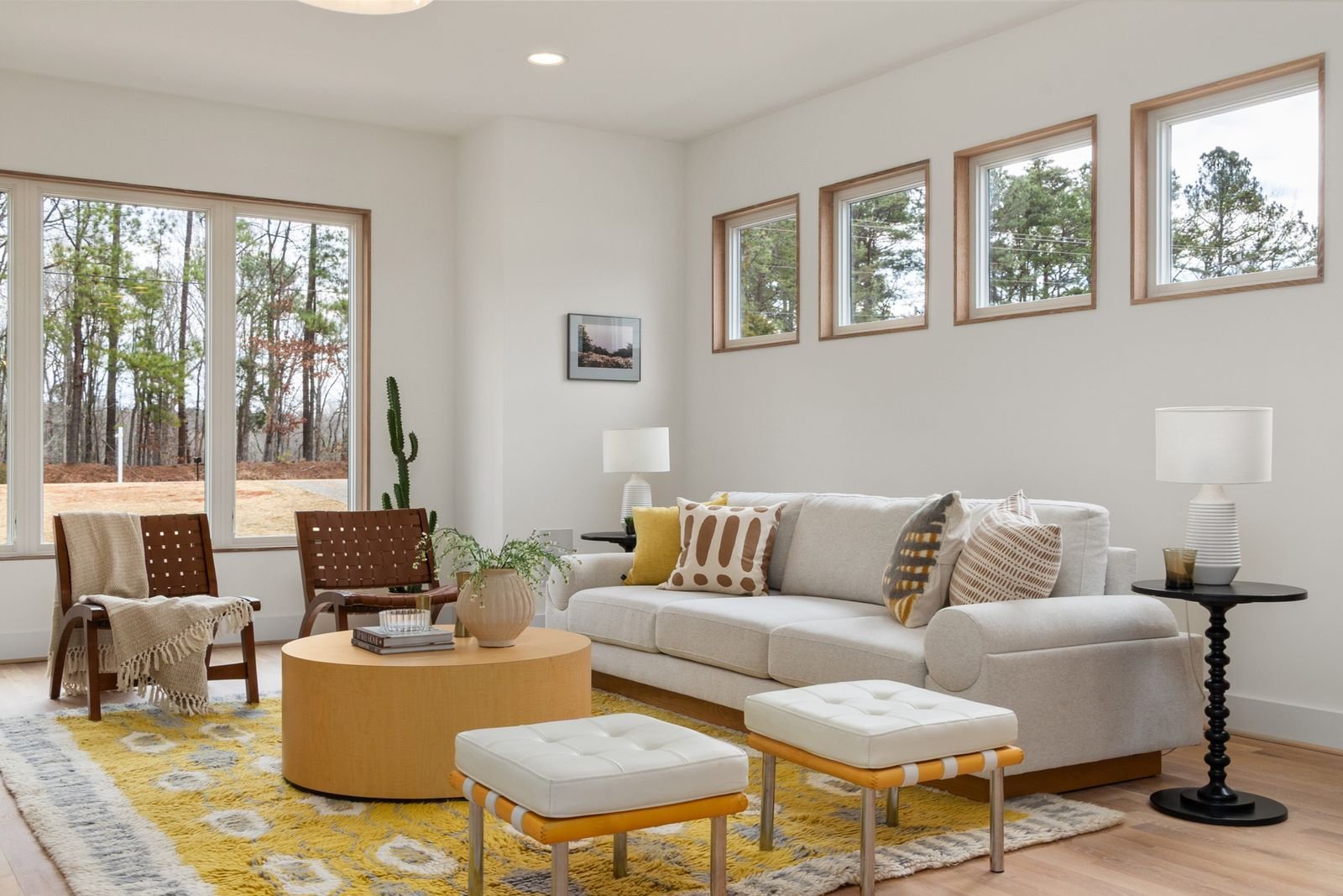 Bright airy minimalist living room with clear open floor space — seating that leaves a clear walkway