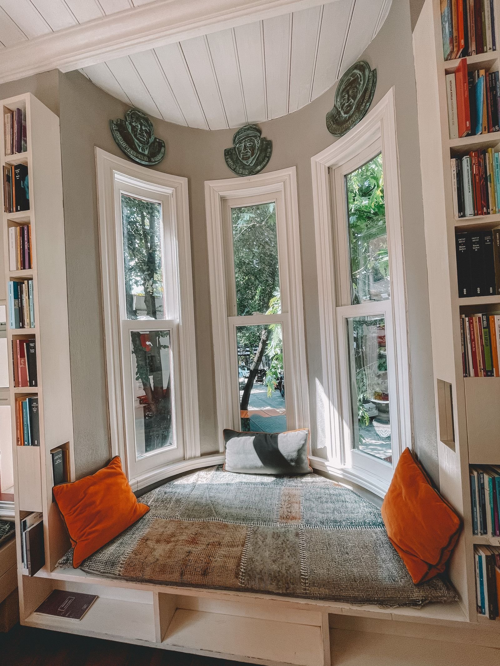 A light living room with a grey fabric ottoman beside a sofa and a potted plant — hidden storage ideas for a small living room