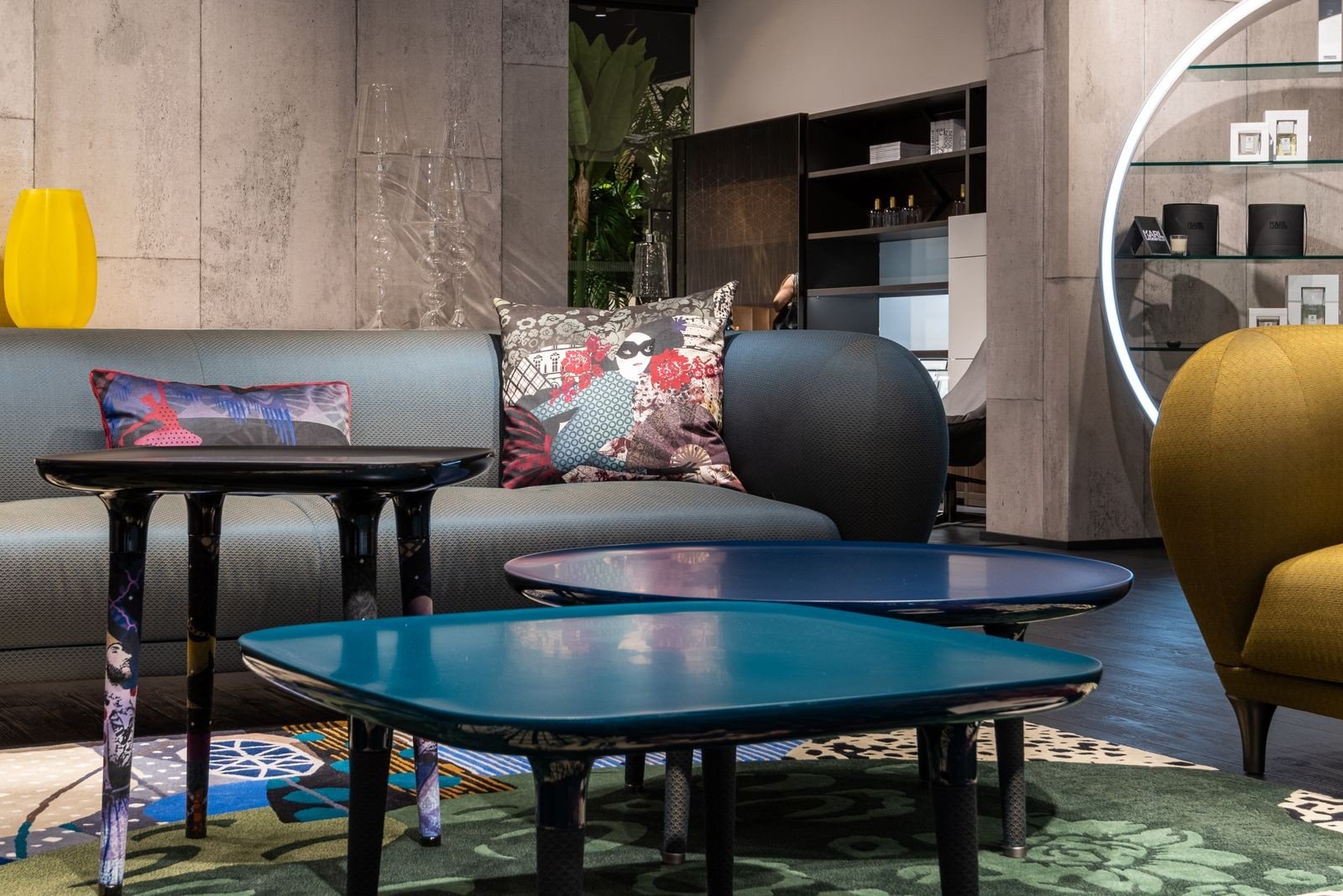 Modern living room with a comfortable couch, patterned cushions and a soft carpet — neutral pieces with colourful accents