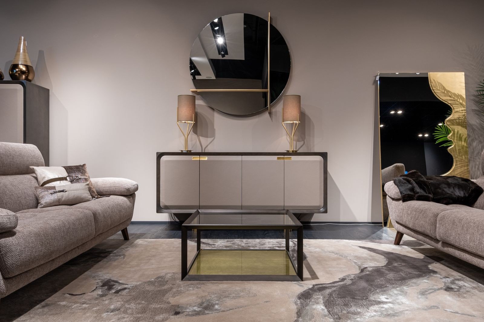 Modern living room with a wall mirror above a cupboard, reflecting warm lamplight to brighten the space
