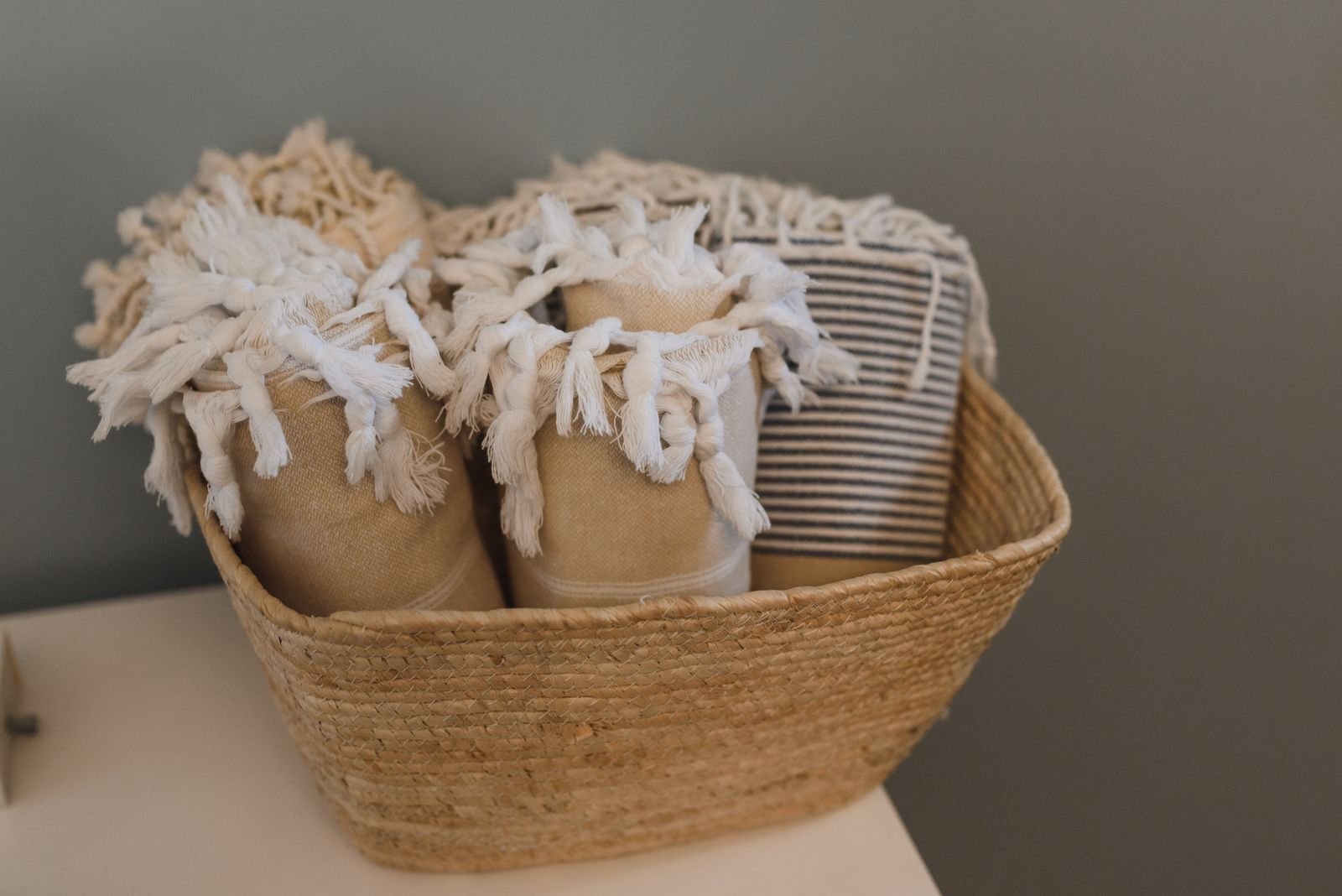 Wicker basket filled with folded cozy throw blankets