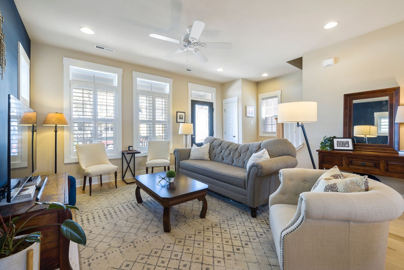 Spacious neutral living room with plush furniture and open floor space