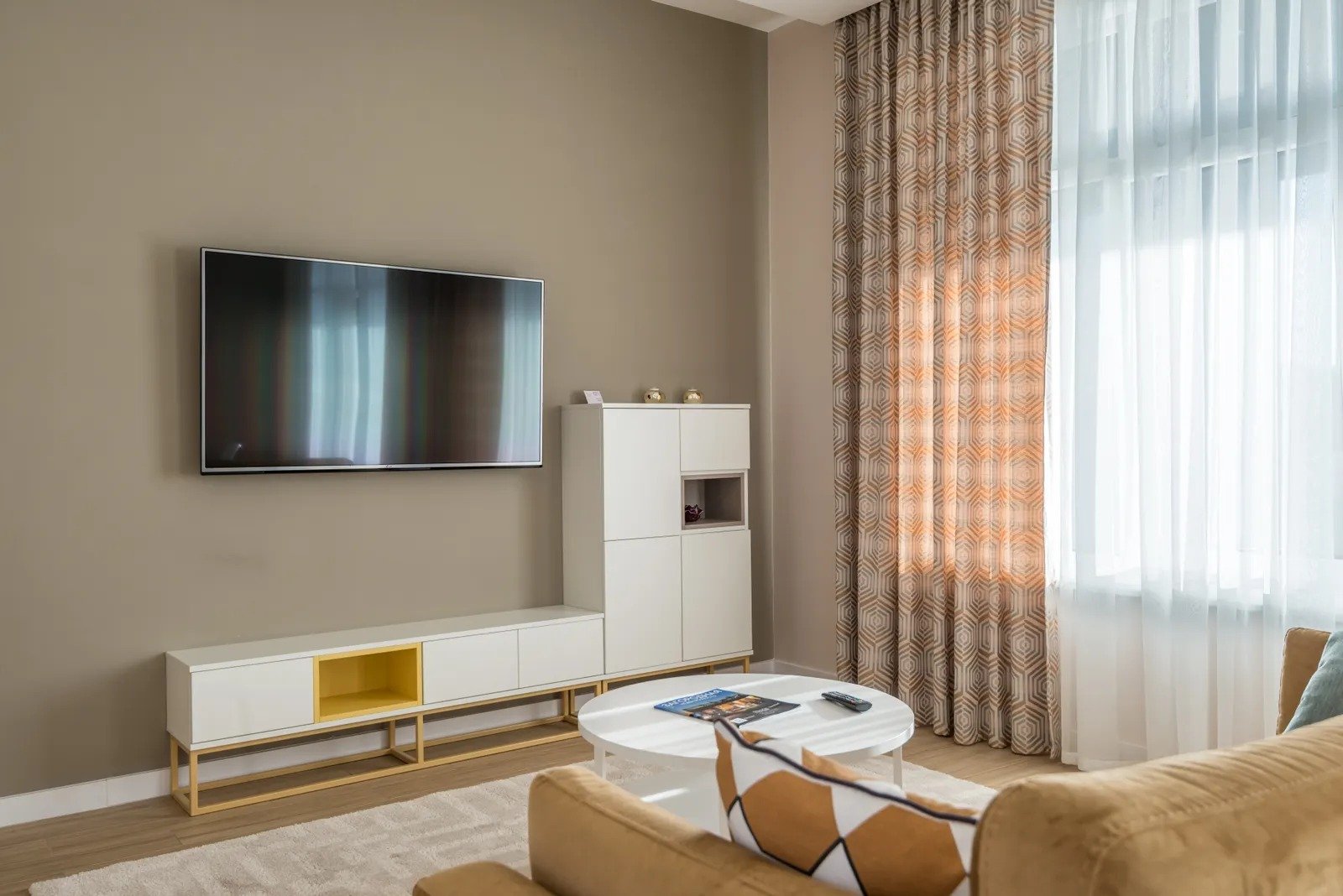 Clutter-free small living room with beige sofa, white closed-storage sideboard, and a tidy coffee table
