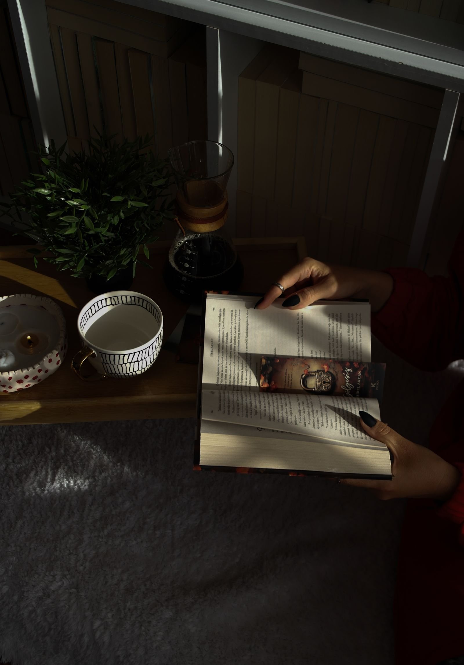 Book and cup of tea in a softly lit cozy reading nook