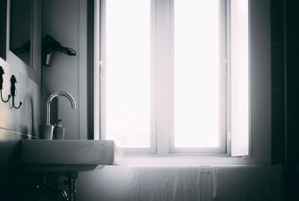 A bright minimalist bathroom sink lit by natural daylight — daylight for small bathroom lighting