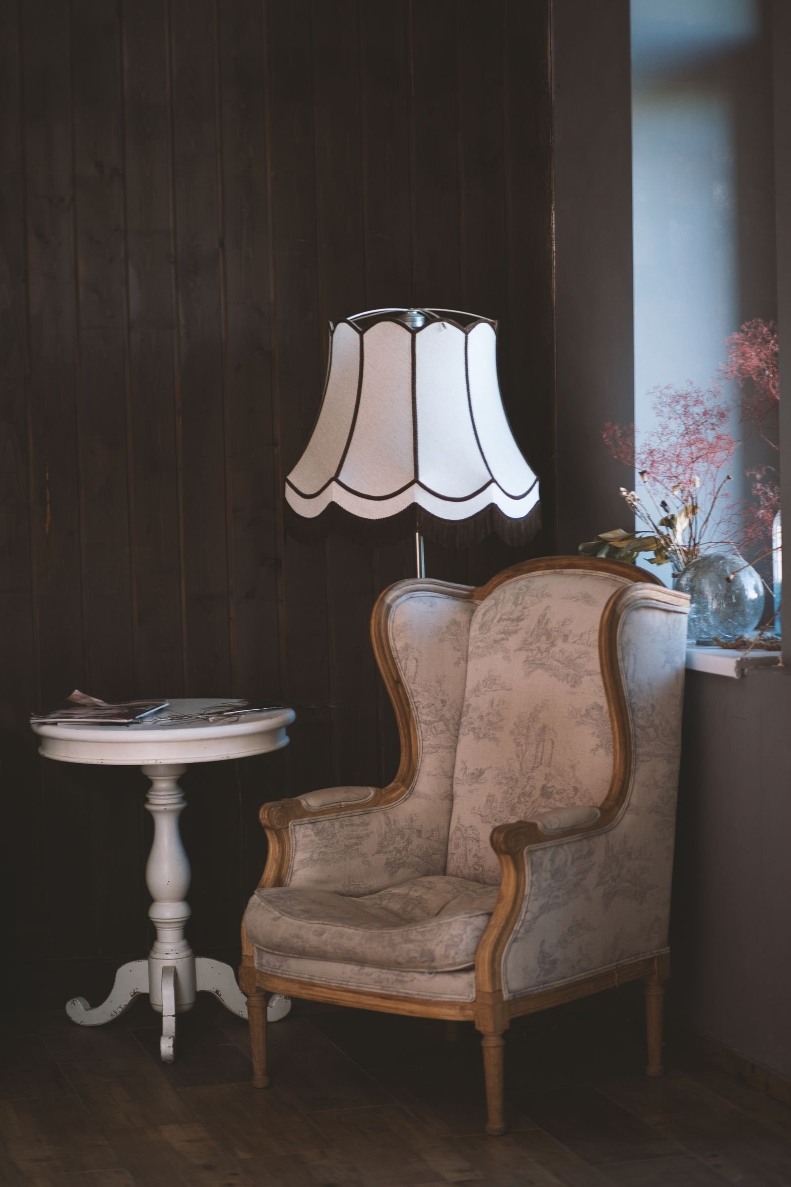 Vintage armchair with elegant lamp and side table in a warm corner