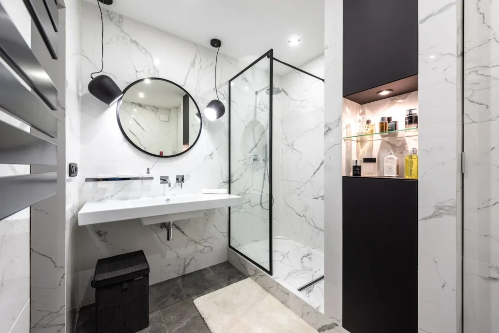 A bathroom mirror between glowing lights above a washbasin — reflective mirror light for small bathroom lighting