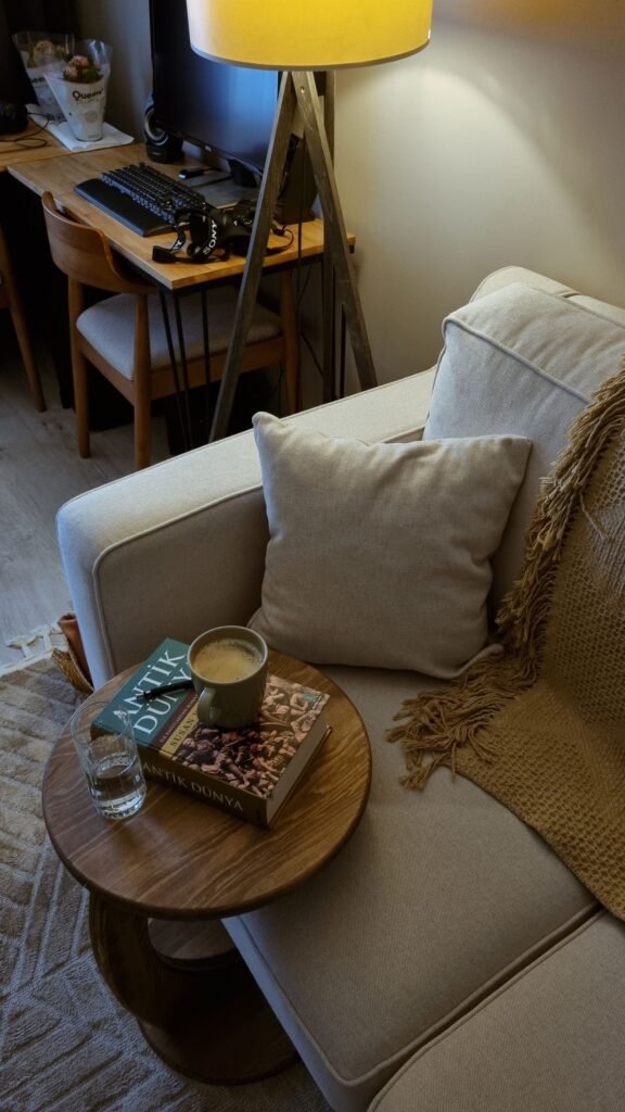 Warm living room corner with a sofa, books, coffee, and ambient lighting — cozy living room