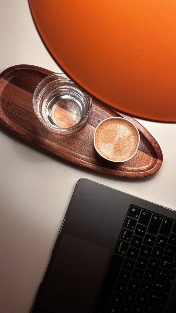 Wooden tray holding a cup of coffee and a glass of water next to a laptop — small living room office