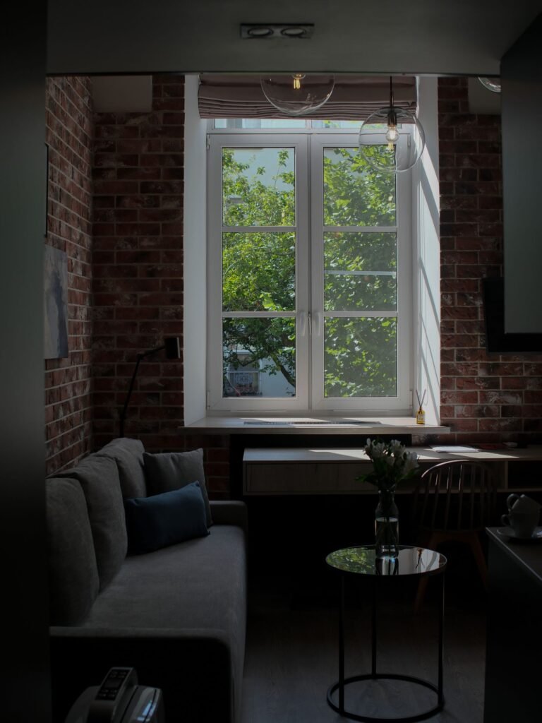 Cozy desk corner with laptop in front of a large window with daylight — work from home living room