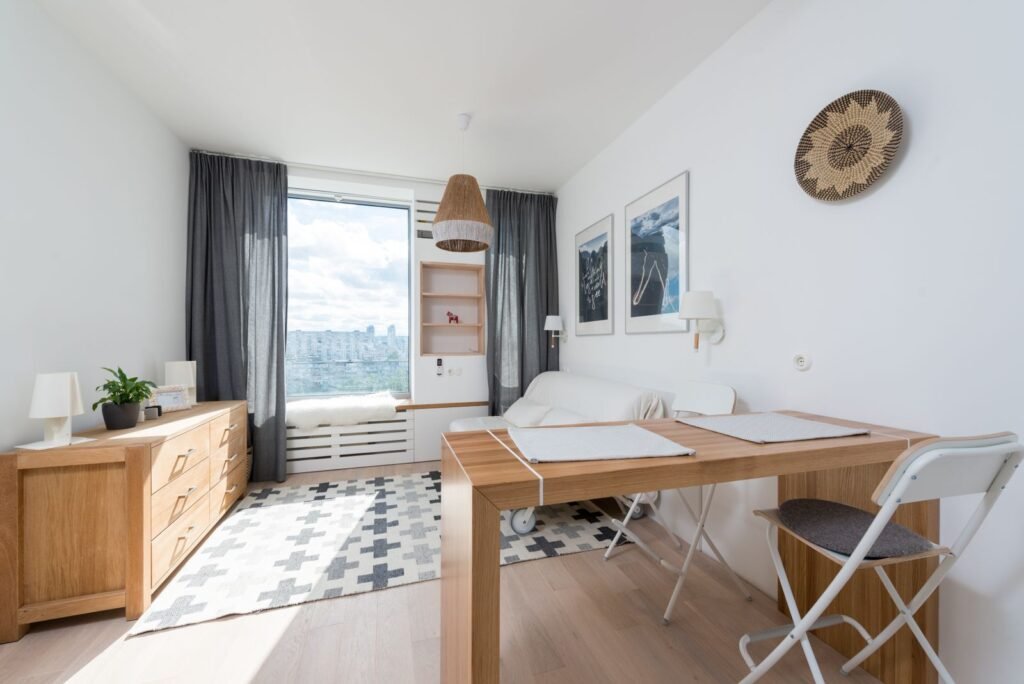Bright living room corner with a curtain dividing the workspace — small living room office