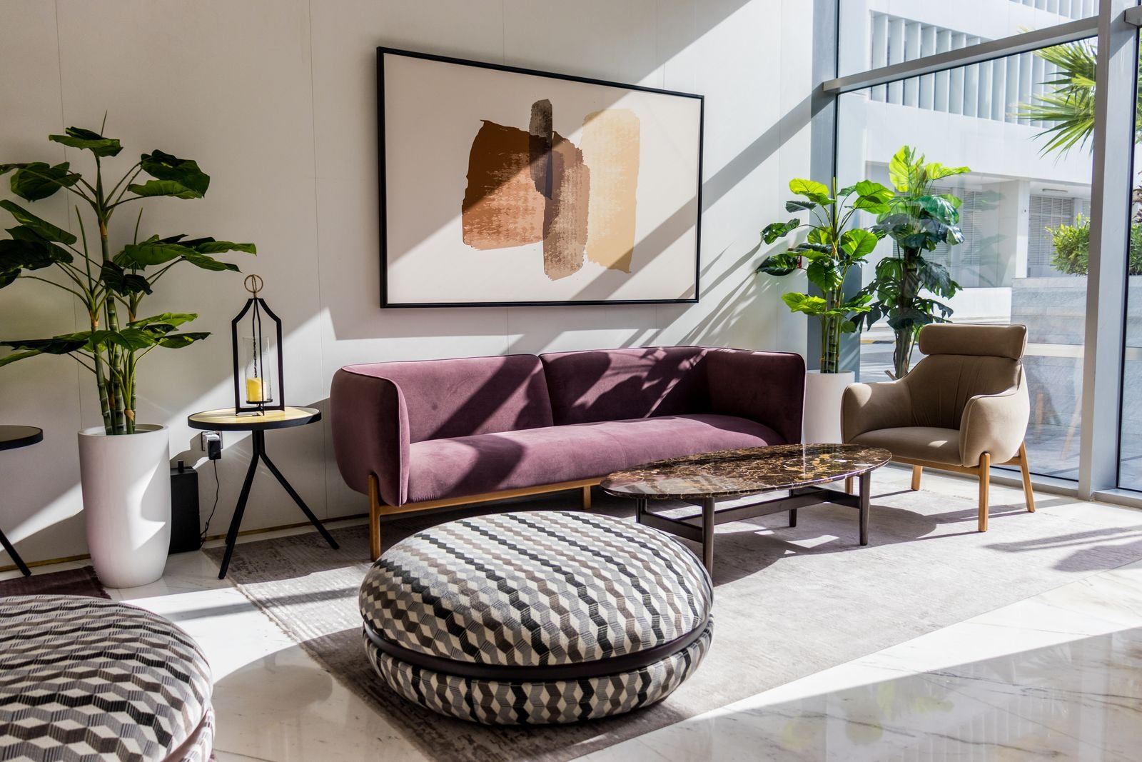 Bright living room with rug, round floor poufs, and mauve sofa