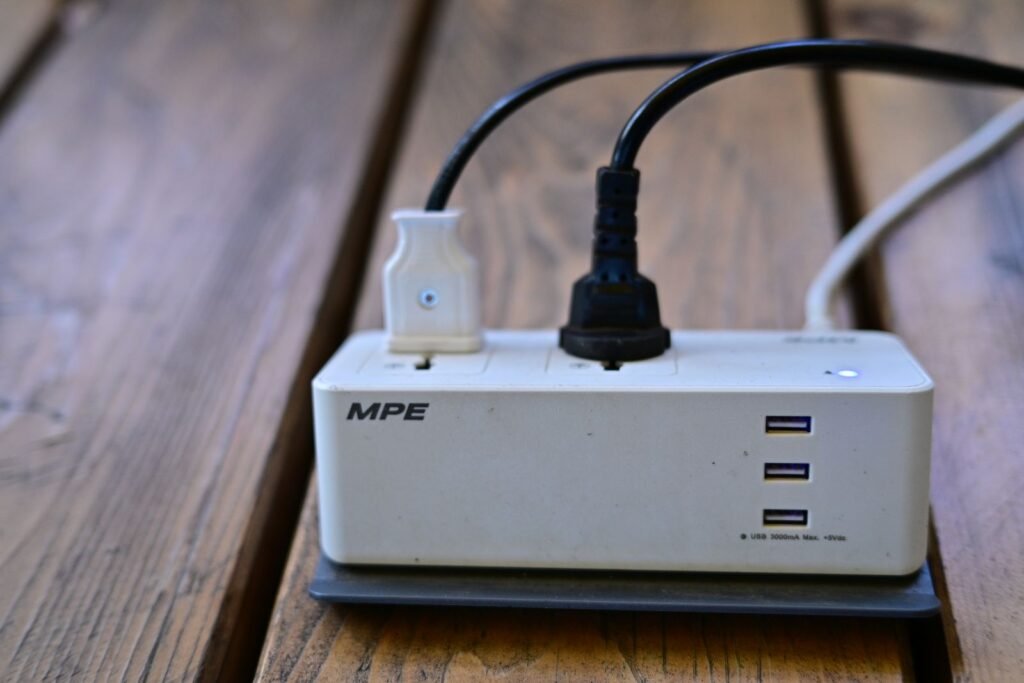 Power strip tucked into a cable box with neatly organized plugs — small living room office