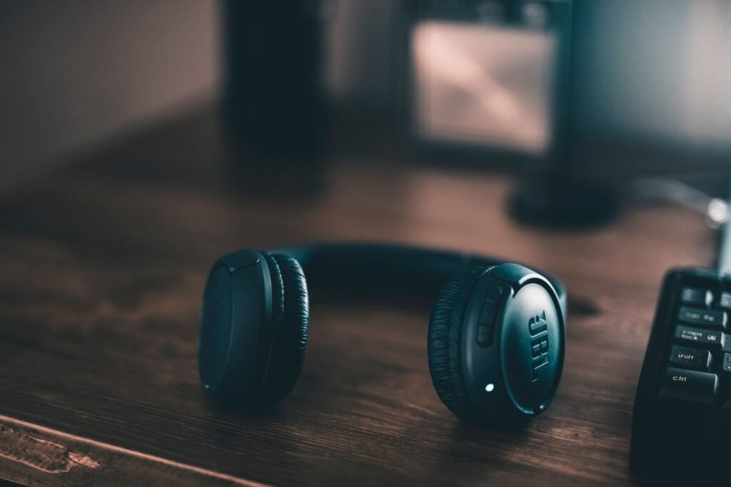 Black headphones resting on a wooden desk — small living room office